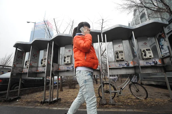 Pedestrian Talks Her Mobile Phone She Walks Empty Telephone Booths — Stock Photo, Image