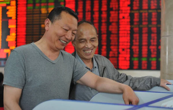 Дві Китайські Інвестори Посміхатися Щасливо Під Час Перевірки Цін Акцій — стокове фото