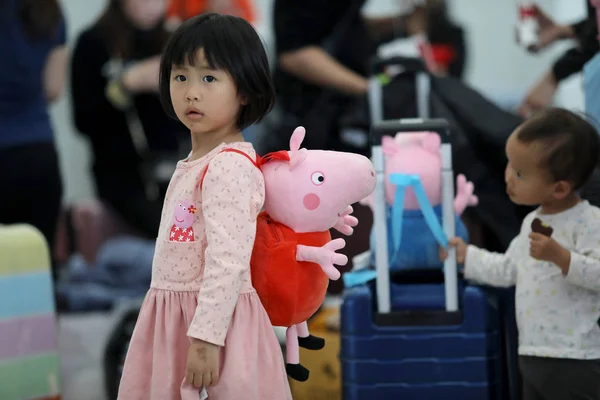 中国の女の子は Chunyun としても知られている春祭りの旅のラッシュの間に家に戻って彼女の道に彼女自身とペッパピッグの形のバッグを運ぶ 南中国の広東省の深圳北駅で 月2019 — ストック写真