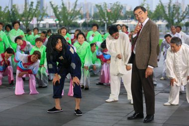 English actor Rowan Atkinson, right, plays Mr. Bean during a filming session for a TV commercial at the Mercedes-Benz Arena in Shanghai, China, 20 August 2014. clipart
