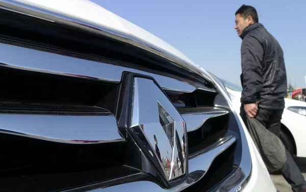 訪問者は青島市 東中国山東省 月2013のオートショーの間にルノーの車を過ぎて歩きます — ストック写真