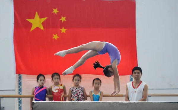2014年8月29日 在中国东部安徽省阜阳市富阳体校进行体操训练时 一名年轻女孩在平衡木上练习 — 图库照片