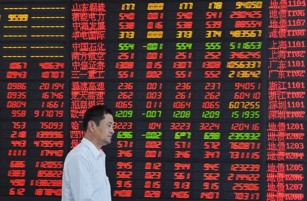 2014年9月2日 在中国东部安徽省阜阳市一家股票经纪公司 一名中国投资者走过显示股价 价格上涨为红色 价格下跌为绿色 的屏幕 — 图库照片