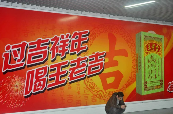 Pedestrian Using His Mobile Phone Squats Front Advertisement Wanglaoji Herbal — Stock Photo, Image