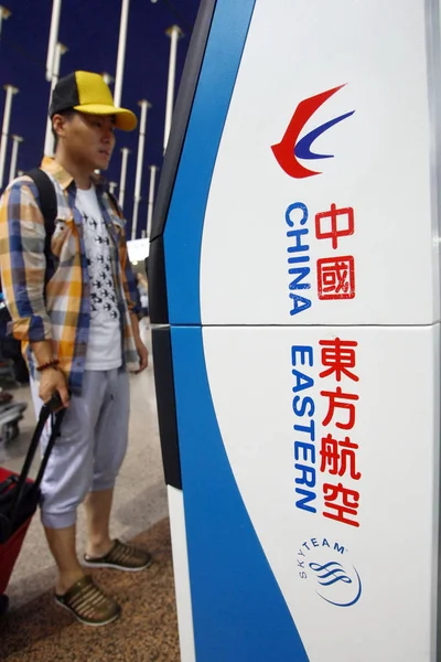 乗客は 中国の上海浦東国際空港で中国東方航空のマシンから彼のチケットを取る準備をします 2014年9月23日 — ストック写真