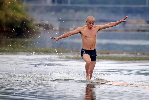中国のシャオリン僧 Shi Liliangは 中国南東部の福建省泉州市のカオバン貯水池の水上の木製の板の上を走る 2014年10月26日 — ストック写真