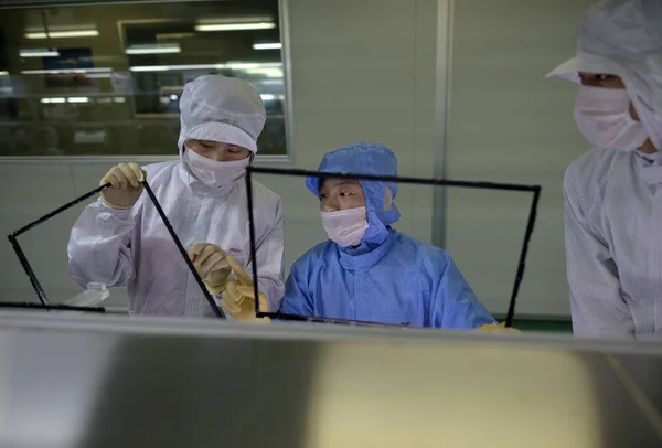 中国の労働者は 武漢市 中央中国湖北省の武漢市の工場でフラットパネルディスプレイを組み立てます 2013年5月8日 — ストック写真