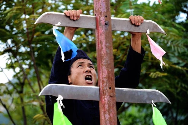 中国のリス少数民族の男性が 2014年9月6日 中国東部山東省青島市の青島森林野生動物の世界で刃のはしごを登る — ストック写真
