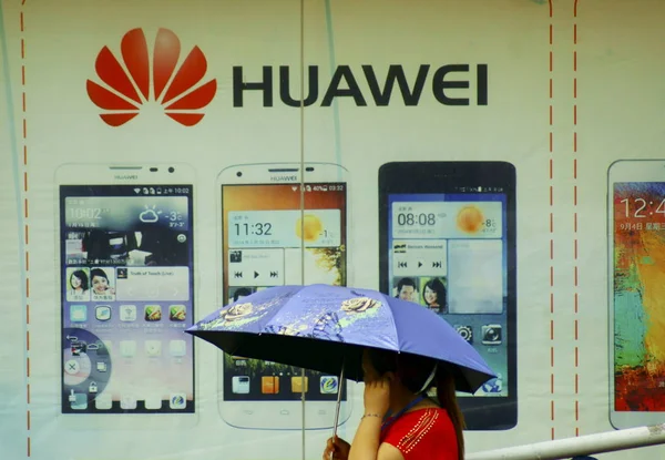 2014년 28일 후베이성 이창시에서 화웨이 스마트폰 광고를 지나걷는 보행자 — 스톡 사진