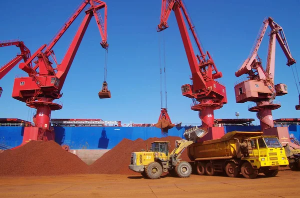 ホイールローダーは 2014年8月3日 中国東部山東省Rizhao市のRizhao港の岸壁に輸入された鉄のオインを積んだトラックを積み込みます — ストック写真