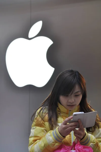 Uma Garota Chinesa Usa Seu Smartphone Iphone Frente Logotipo Apple — Fotografia de Stock