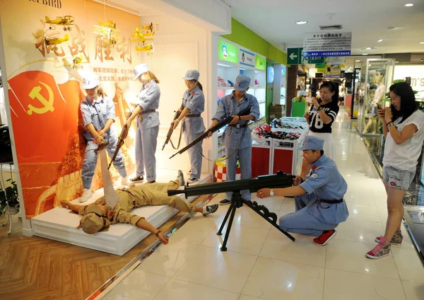 身着八路军蓝色制服的中国职员 在中国北方山西省太原市一家商场的促销活动中 用玩具枪瞄准二战期间一名身穿日军制服的员工 — 图库照片