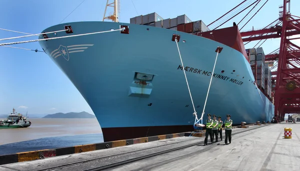 Chinese public securities walk past the Maersk Mc-Kinney Moeller Triple-E class container vessel, the worlds largest ship as it arrives at the Ningbo port in Ningbo, east Chinas Zhejiang province, 20 July 2013 — Stock Image Chinese Public Securities Walk Maersk Kinney Moeller Triple Class Container Stock Photo
