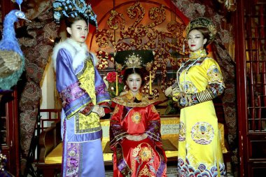 Members of South Korean girl group Swing Girls dressed in traditional Chinese royal costume pose for photos during a visit to a local ancient costume photography city in Zhengzhou city, central China's Henan province, 23 November 2014. clipart