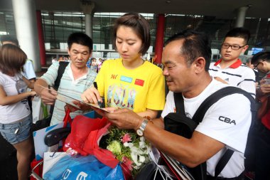 Female Chinese swimmer, Jiao Liuyang, second right, autographs for fans after she arrived back from the World Championship in Barcelona at the Beijing Capital International Airport in Beijing, China, 6 August 2013. clipart