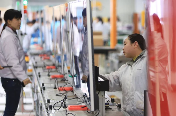 中国の女性労働者は 2014年3月25日 中国中部湖南省河陽市のフォックスコン テクノロジー グループが所有するホン フジン精密工業 Hengyang 社の工場で Letvのスマートテレビセットを調べる — ストック写真