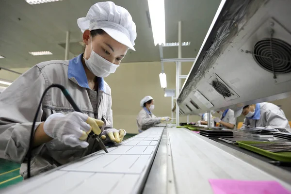 女性中国人労働者は 中国東部江蘇省江蘇省梁陽市の上海深州新エネルギー開発有しの工場で ヨーロッパと米国に輸出される太陽光パネル用の太陽光発電セルを溶接した — ストック写真