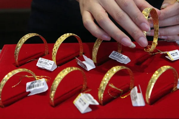 中国書記官は楡県 東の中国の江蘇省 2013 日の金ショップで販売のカウンターに金のブレスレットを置く — ストック写真
