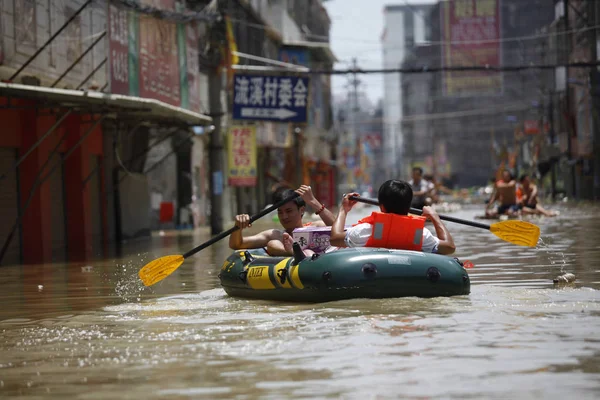 2013年8月19日 中国广东省东北部汕头市遭遇台风乌托袭击后 中国人坐在一条被淹街道上的橡皮艇上 — 图库照片