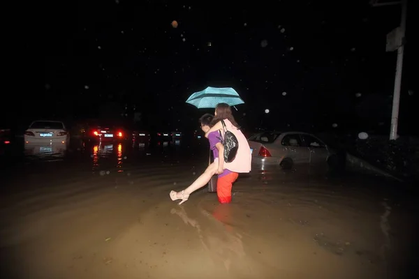 Młody Chiński Człowiek Nosi Swoją Dziewczynę Plecach Jak Braves Powodzi — Zdjęcie stockowe