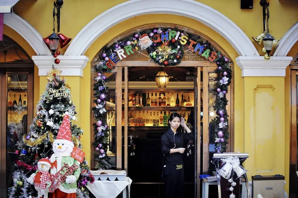 2014年12月9日 中国南部の広東省仏山市にあるShui Land Limitedが開発した商業用不動産プロジェクト 仏山リンナンティアンディ のクリスマスをテーマにしたレストランの入り口にウェイトレスが立っている — ストック写真