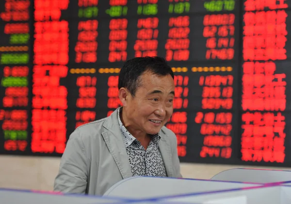 Китайский Инвестор Улыбается Глядя Цены Акции Красный Роста Цен Зеленый — стоковое фото