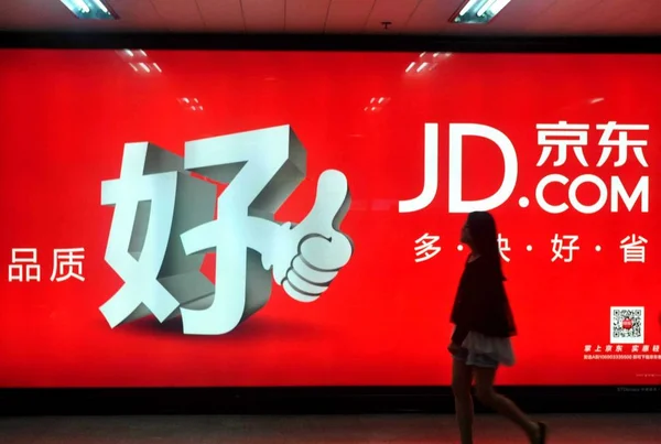 ペデストレインは 以前は中国の上海でJingdong Comまたは360Buy Comと呼ばれていたオンラインショッピングサイトJd Comの広告を通り過ぎる 2013年5月25日 — ストック写真