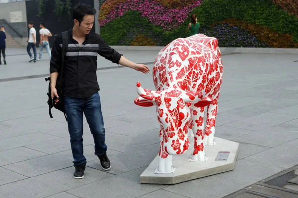 訪問者は バンド 2014年9月29日に2014年カウパレード上海の間に牛の装飾された彫刻を見ます — ストック写真