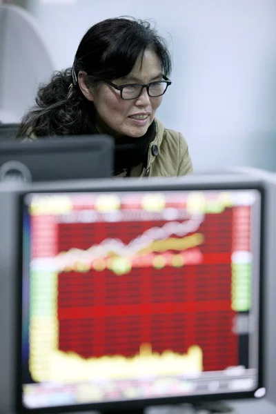 Kinesisk Investor Ser Datamaskinutstilling Som Viser Shanghai Composite Index Aksjemeglerhus – stockfoto