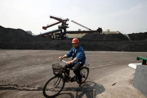 2012年10月10日 中国東部安寧省華北市の炭鉱の石炭田で 中国人労働者が石炭の山を越えて自転車に乗る — ストック写真
