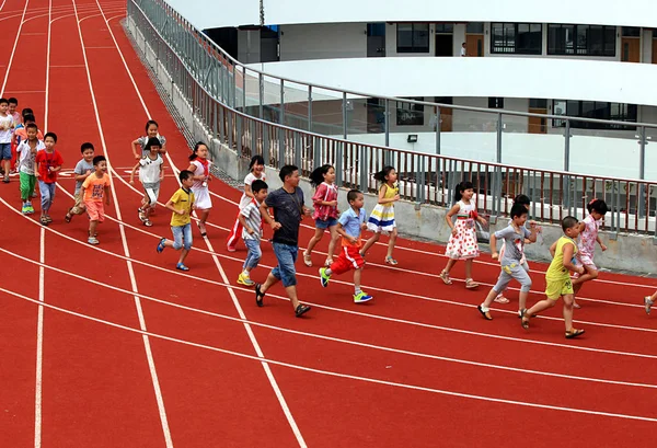 2014年9月1日 中国浙江省东部台州市天台县赤城街第二小学楼顶轨道上 学生们跑着 — 图库照片
