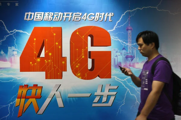 歩行者は 中国の中国モバイル4Gネットワークの広告を通り過ぎる 2013年6月8日 — ストック写真