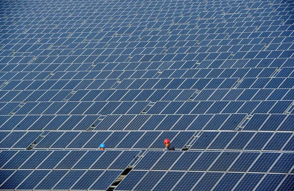 中国人労働者は 杭州市の建物の屋上にある太陽光発電所でソーラーパネルの配列をチェックし 2012年2月2日 — ストック写真