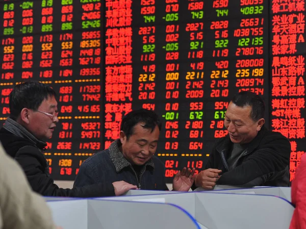 Китайские Инвесторы Разговаривают Перед Экраном Показывающим Цены Акции Красный Роста — стоковое фото