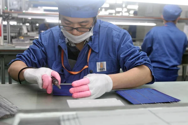中国の労働者は 2013年3月26日 中国東部江蘇省南通市のハンファ ソラーロン社の工場で太陽光パネルを製造するために太陽光発電 セルを溶接した — ストック写真