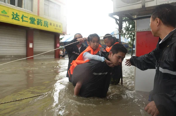 2013年7月9日 在中国四川省西南部成都市 一名中国救援人员在一条被洪水淹没的街道上搭载一名年轻女孩 — 图库照片