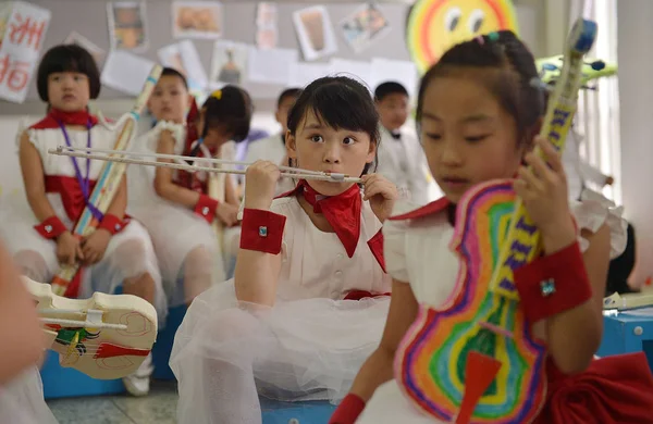 2013年5月30日 中国南西部の成都市にある嘉義小学校でのリハーサル中に先生の話を聞きながら 紙で作った楽器を持っている — ストック写真