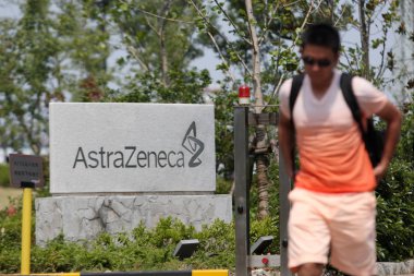 A pedestrian walks past the China headquarters of AstraZeneca in Pudong, Shanghai, China, 23 July 2013 clipart