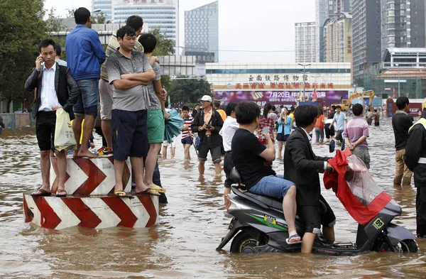 ローカル市民は 2013 日南西中国雲南省昆明市の豪雨後に冠水した通りに見られています — ストック写真