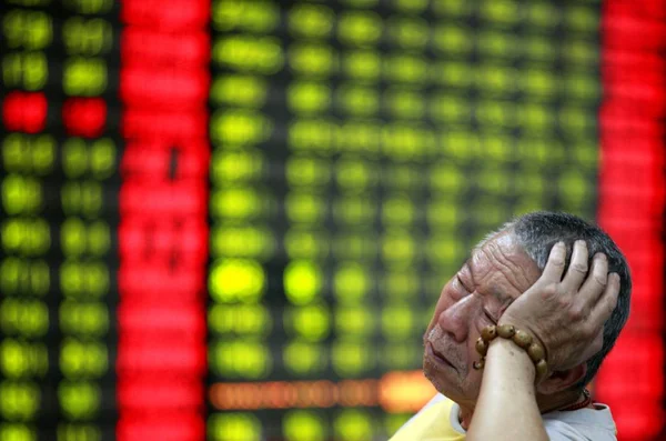 中国の投資家は Huaibei 東中国安徽州の株式仲買家で株式の価格を見て 価格上昇のための赤 価格下落のための緑 2013 月17日 心配そうに見えます — ストック写真