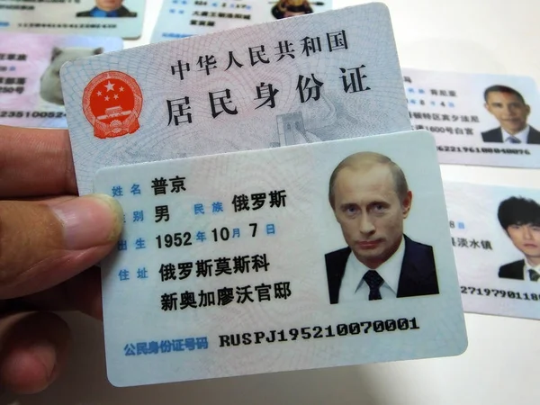 広州市 中国南部広東省の通りの屋台で販売のためのロシアのウラジミール プーチン大統領の偽の中国のIdカードを示しています 2013年6月27日 — ストック写真