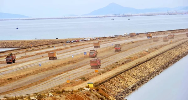 大型トラックは 山から取り除かれた土石を 中国北東部の遼寧省大連市の沖合いの空港の建設現場に輸送し 2014年9月14日 — ストック写真