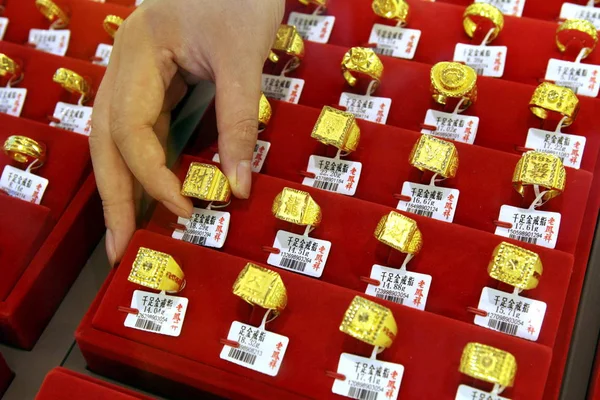 中国書記官は 2014 日東中国江蘇省連雲港市の宝石店でカウンターに金の指輪を置く — ストック写真