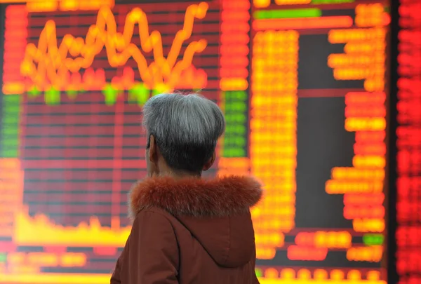 2014年11月26日 中国投资者在中国东部安徽省阜阳市一家股票经纪公司查看股票指数 — 图库照片