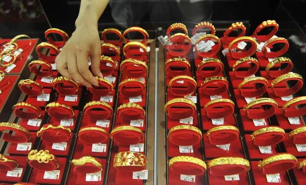 中国書記官は駐屯とその 東中国浙江省 2013 日の金ショップで販売のカウンターに金のブレスレットを置く — ストック写真