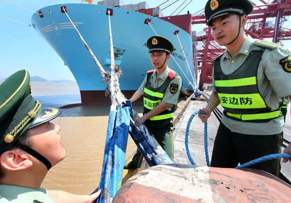 Chinese public securities check the mooring for the Maersk Mc-Kinney Moeller Triple-E class container vessel, the worlds largest ship as it arrives at the Ningbo port in Ningbo, east Chinas Zhejiang province, 20 July 2013 — Stock Image Chinese Public Securities Check Mooring Maersk Kinney Moeller Triple Class Stock Photo