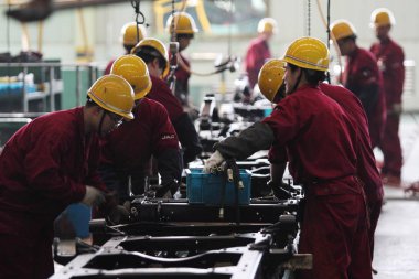Chinese workers labor at the auto plant of Anhui Jianghuai Automobile Co., Ltd. (JAC) in Hefei city, east Chinas Anhui province, 15 March 2014 clipart