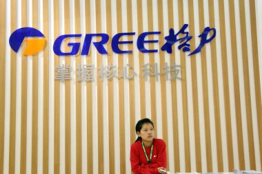 A Chinese employee is seen at the stand of Gree during a fair in Shanghai, China, 5 December 2014.  clipart