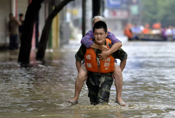 Китайский Спасатель Везет Пожилую Женщину Затопленной Улице Вызванной Обильным Дождем — стоковое фото