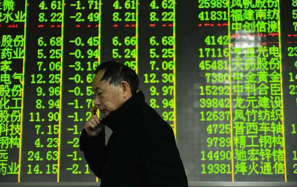 2013年3月26日 在中国浙江省东部杭州市一家股票经纪公司 一名中国投资者走过显示股价 绿色价格下跌 的屏幕 — 图库照片